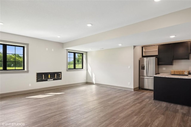 interior space featuring dark hardwood / wood-style floors, stainless steel fridge, and dark brown cabinetry