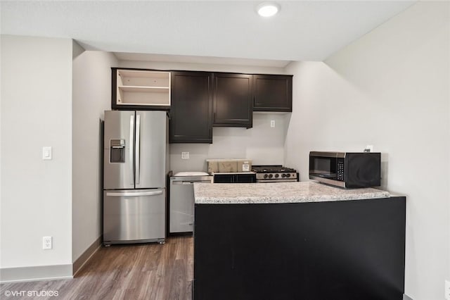 kitchen featuring light stone counters, hardwood / wood-style floors, dark brown cabinetry, and stainless steel appliances