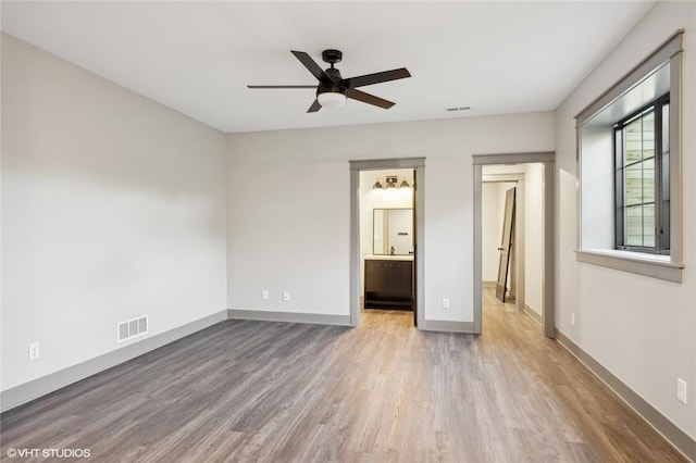 unfurnished bedroom featuring ceiling fan, connected bathroom, and light hardwood / wood-style floors