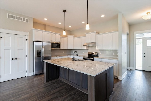 kitchen featuring appliances with stainless steel finishes, a kitchen island with sink, sink, pendant lighting, and white cabinets