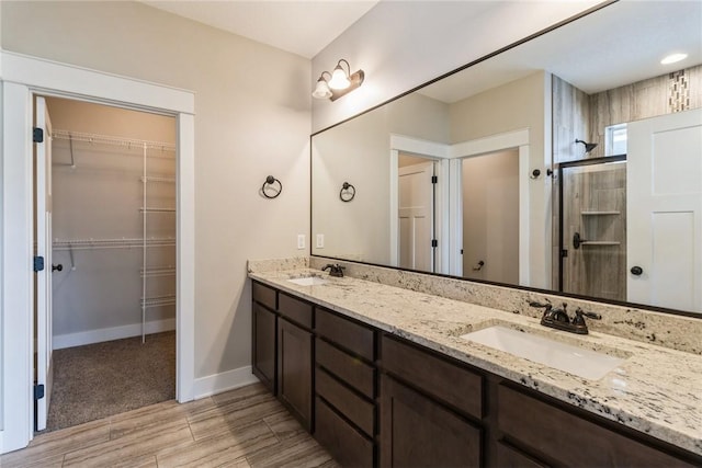 bathroom featuring a shower with door and vanity