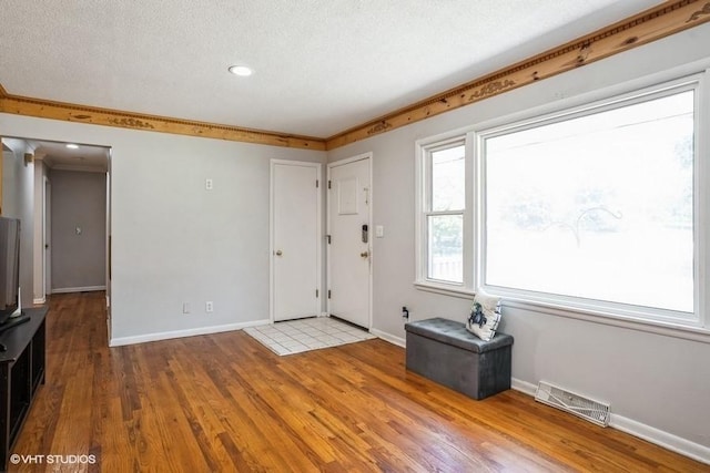 foyer with light hardwood / wood-style flooring and a textured ceiling