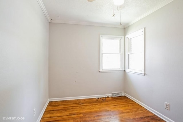 empty room featuring ceiling fan, ornamental molding, hardwood / wood-style floors, and a textured ceiling