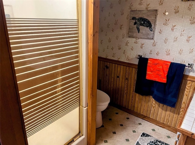 bathroom featuring an enclosed shower and wooden walls