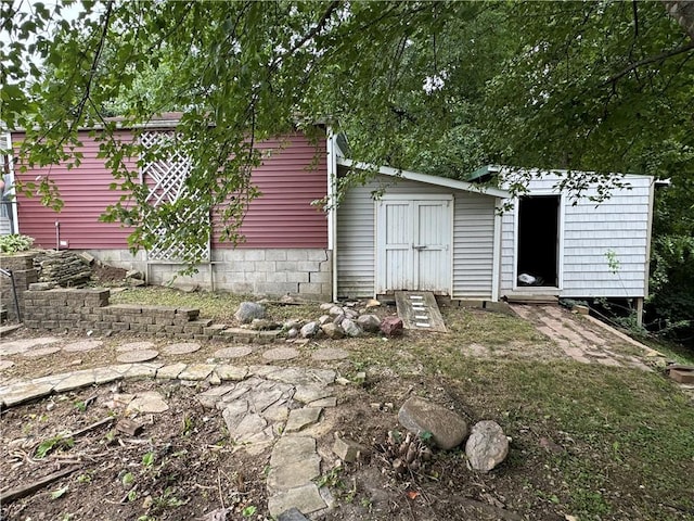 rear view of house featuring a storage unit