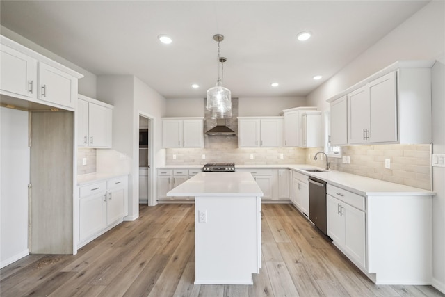 kitchen featuring dishwasher, white cabinetry, a center island, decorative light fixtures, and wall chimney exhaust hood