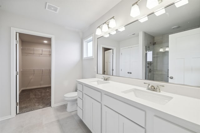 bathroom with tile patterned flooring, vanity, toilet, and a shower with shower door