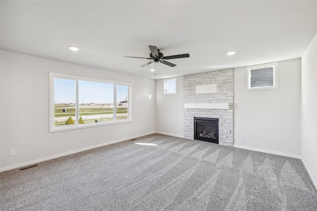 unfurnished living room featuring a fireplace, carpet flooring, and ceiling fan