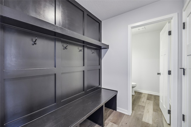 mudroom with light hardwood / wood-style flooring and a textured ceiling