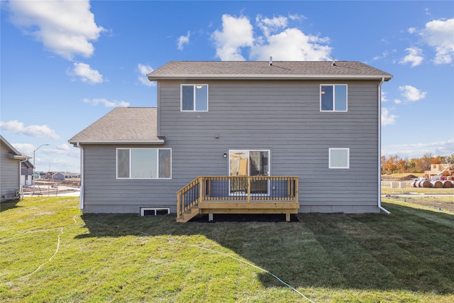 back of property with a wooden deck and a lawn