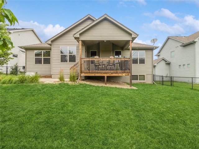 rear view of house featuring a deck and a lawn