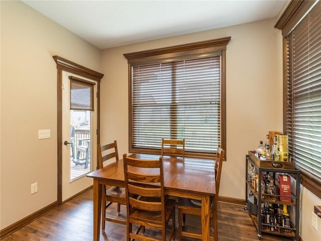 dining space with a wealth of natural light and dark hardwood / wood-style flooring