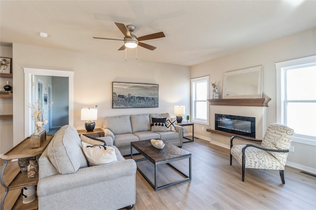 living room featuring ceiling fan and light wood-type flooring