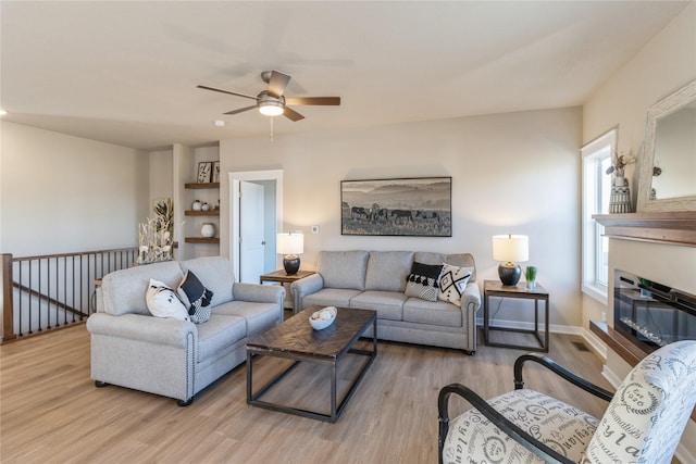 living room with ceiling fan and light hardwood / wood-style flooring