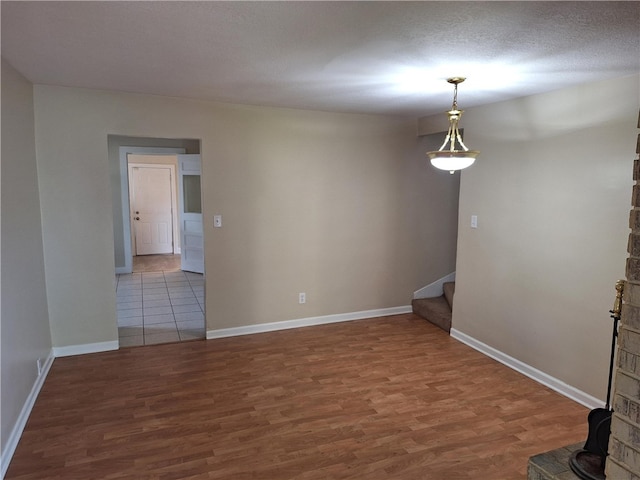 spare room featuring a textured ceiling and hardwood / wood-style floors