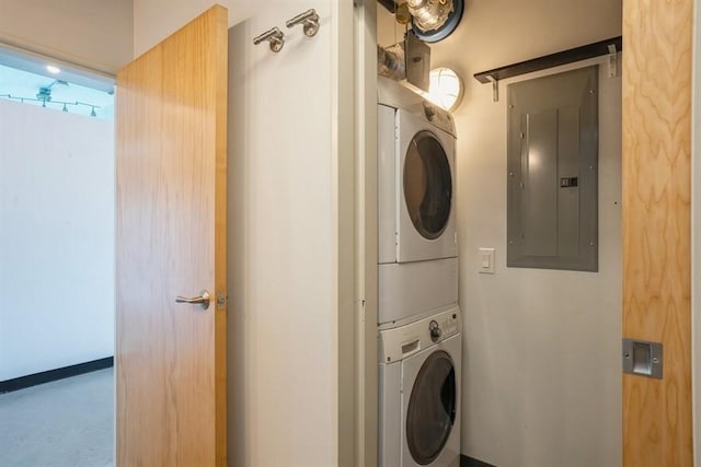 laundry room featuring stacked washer / drying machine and electric panel