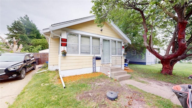 bungalow featuring a front lawn