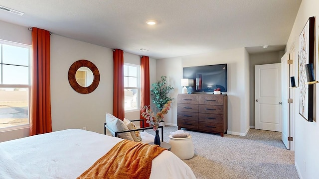 bedroom featuring baseboards, visible vents, and light carpet