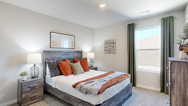 bedroom with light carpet, visible vents, and baseboards