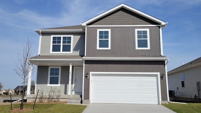 view of front facade with cooling unit, concrete driveway, a garage, and a shingled roof