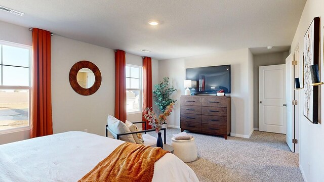 bedroom featuring light carpet, visible vents, and baseboards