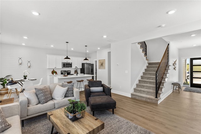 living room featuring light hardwood / wood-style flooring and sink