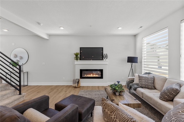 living room with beam ceiling and light wood-type flooring