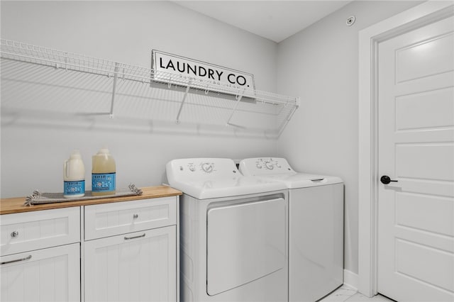 laundry area featuring cabinets and washing machine and dryer