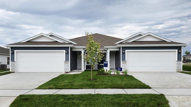 view of front of home with a garage, a front lawn, and cooling unit