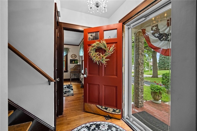 entryway with an inviting chandelier and light hardwood / wood-style flooring