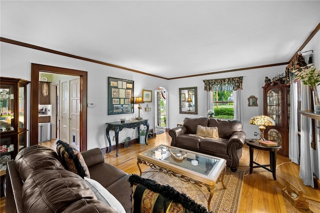 living area featuring crown molding, baseboards, and wood finished floors