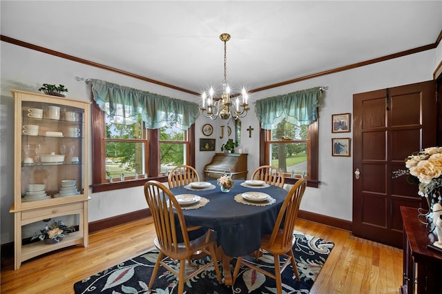 dining room featuring baseboards, light wood-type flooring, and crown molding