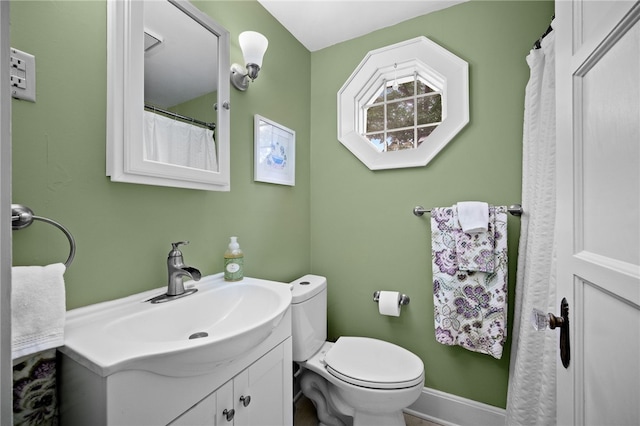 full bathroom with toilet, vanity, and baseboards