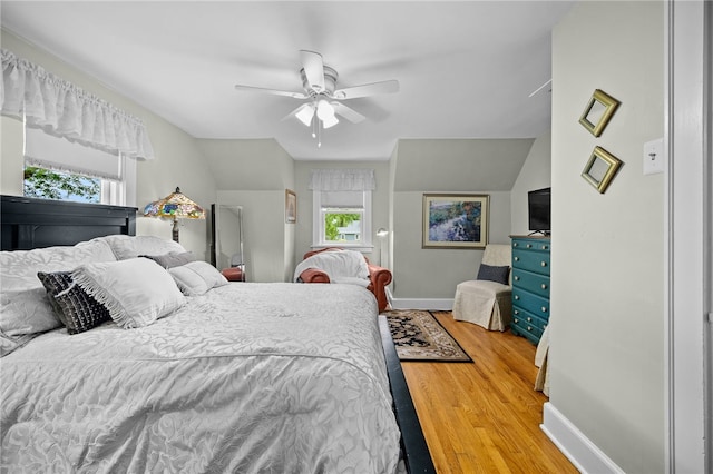 bedroom with ceiling fan, baseboards, vaulted ceiling, and wood finished floors