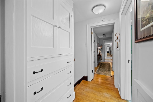 hallway featuring baseboards and light wood-style floors