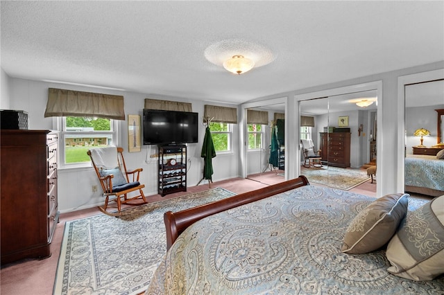 bedroom featuring a textured ceiling and two closets