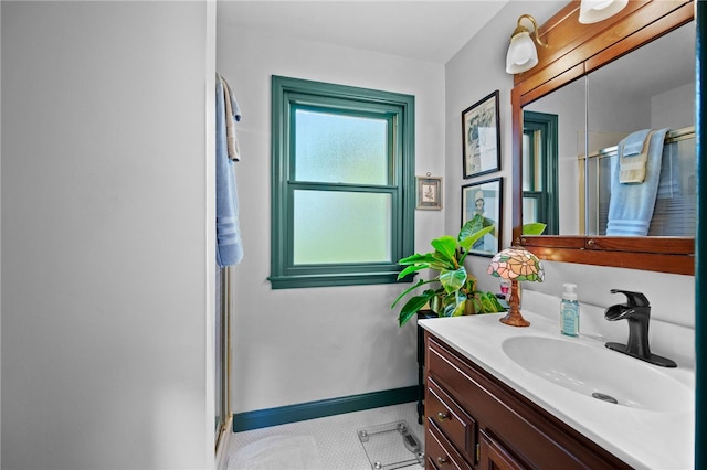 bathroom featuring baseboards, vanity, and a shower stall