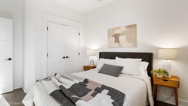 bedroom with baseboards, a closet, and wood finished floors