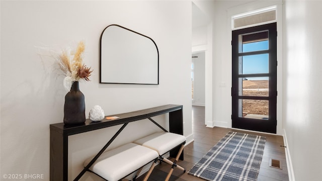 foyer featuring wood finished floors, visible vents, and baseboards