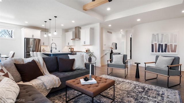 living area featuring recessed lighting, wood finished floors, visible vents, baseboards, and beamed ceiling