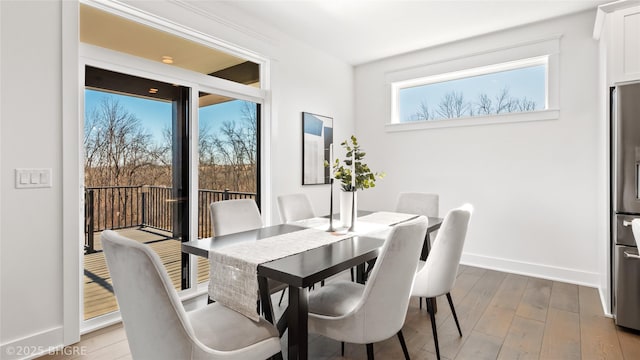 dining area featuring wood-type flooring and baseboards