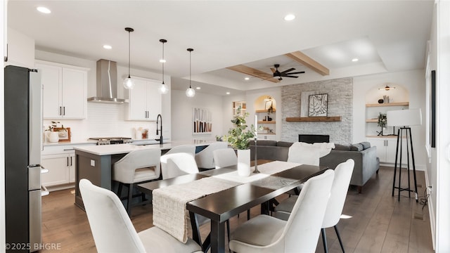 dining space featuring a ceiling fan, recessed lighting, a stone fireplace, and hardwood / wood-style flooring