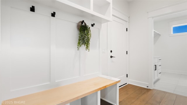 mudroom featuring light wood-style flooring and baseboards