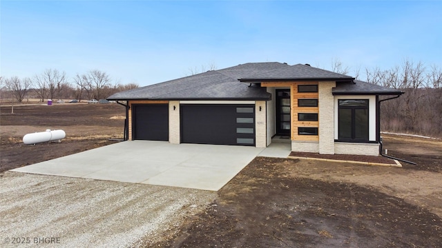 view of front of house featuring a garage, concrete driveway, and roof with shingles