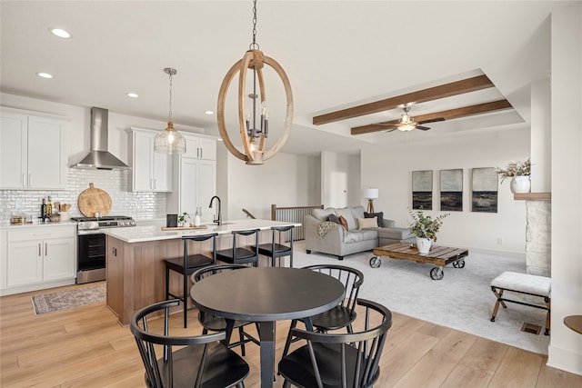 dining room featuring light wood-type flooring, ceiling fan, and sink