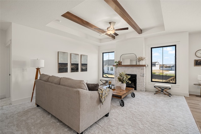 living room with ceiling fan, a raised ceiling, and light hardwood / wood-style flooring