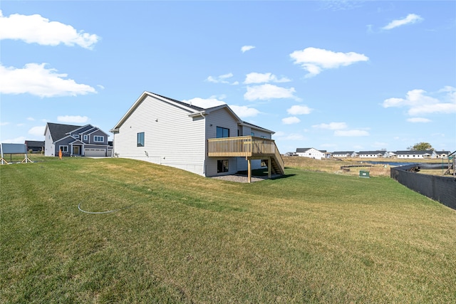 back of house with a deck and a lawn