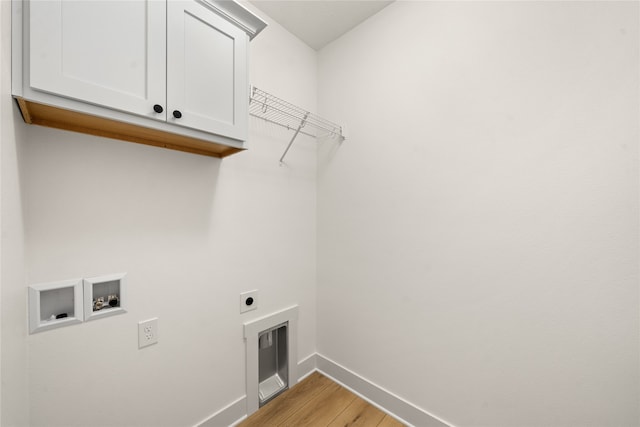 laundry room with cabinets, hookup for a washing machine, light hardwood / wood-style floors, and electric dryer hookup