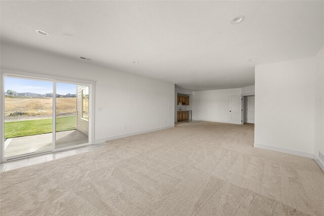 unfurnished living room featuring light colored carpet