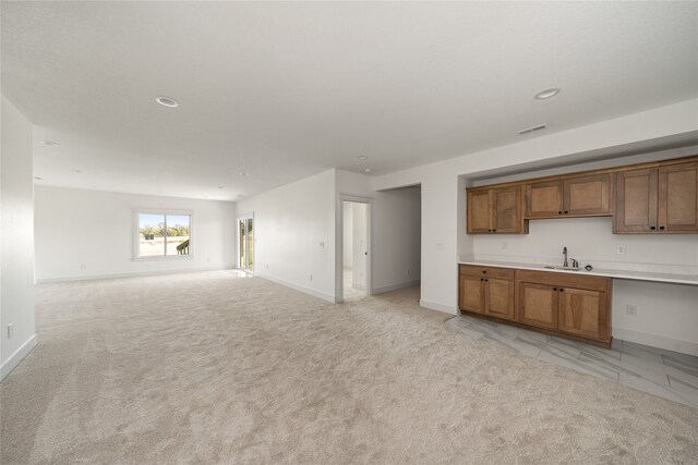 kitchen featuring sink and light carpet